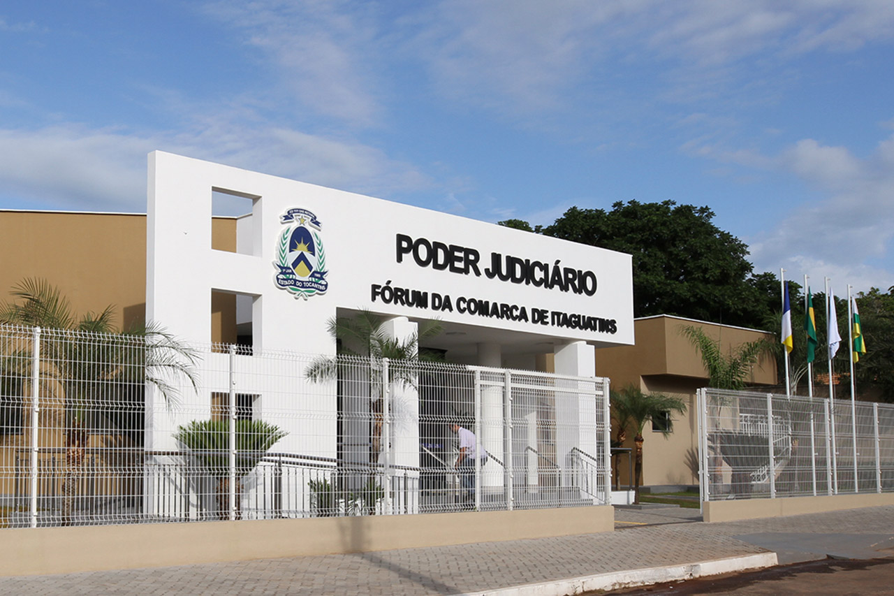 Fachada principal do fórum de Itaguatins, nas cores branca e marrom. O prédio possui cerca de segurança e jardim exerno