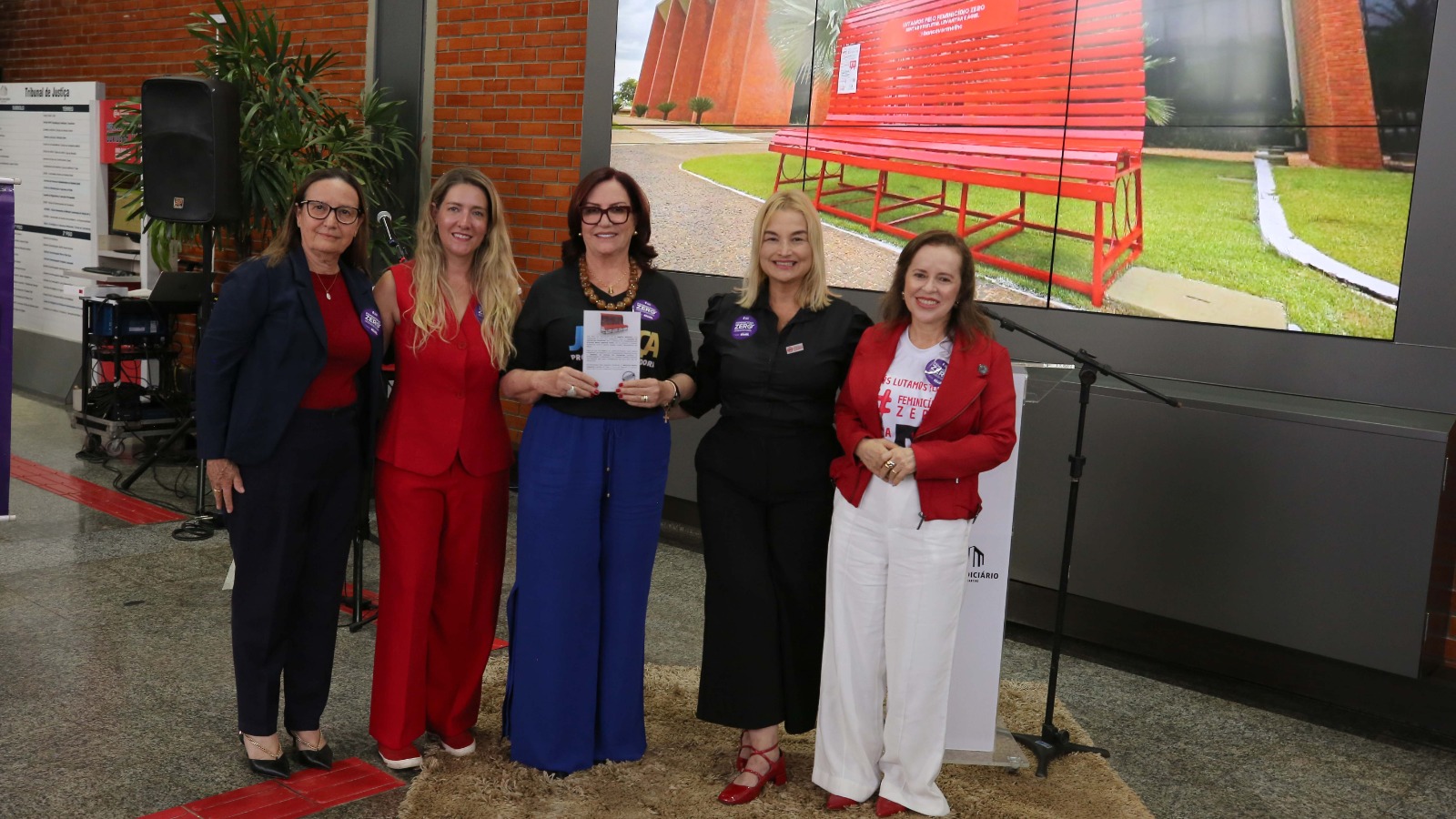 Desembargadora Etelvina, ao centro, segura uma placa de homenagem; ao seu lado, as duas representantes do Instituto Banco Vermelho, a desembargadora Maysa e a juíza Cirlene